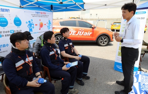 ▲13일 서울 강서구 김포국제공항 보호구역에서 제주항공 정비사들이 온열질환 예방 캠페인에 참여하고 있다. [사진= 제주항공 제공]