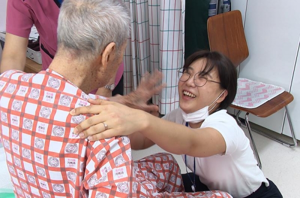 산책을 마치고 돌아온 김행선(90세, 알츠하이머 2016년 진단)할아버지가 송보름달 인천광역치매센터 간호사(휴머니튜드 전문교육자)와 하이파이브를 하고 있다.(사진제공=인천시)