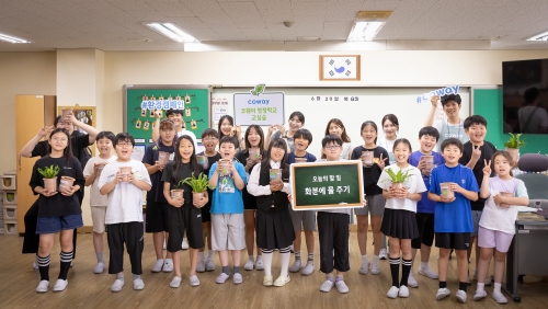▲ 코웨이 임직원 봉사자들과 초등학생들이 '청정학교 교실숲 제6호' 조성 기념 단체 사진을 찍고 있다. [사진= 코웨이 제공]