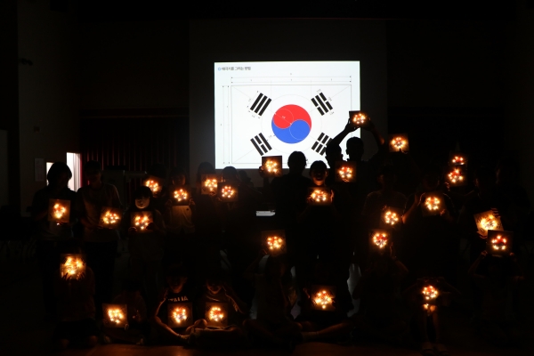 태극기 모양 '뚝딱뚝딱 숲울림공방 프로그램' 결과물을 들고 찍은 단체촬영 모습. (사진제공=한국산림복지진흥원 국립대전숲체원)