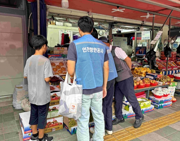 인천항만공사 직원과 아동이 전통시장에서 장을 보고있다.(사진제공=인천항만공사)