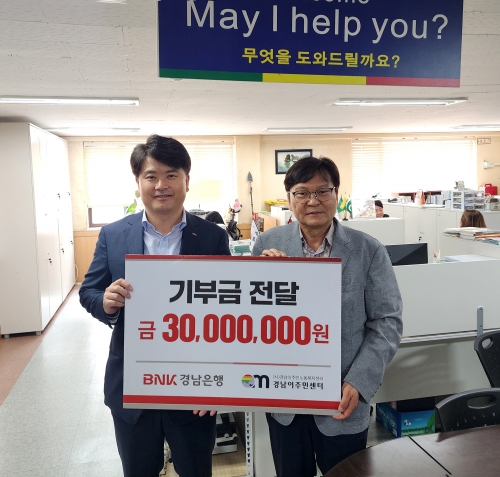 BNK경남은행 홍응일 상무(사진 왼쪽)가 (사)경남이주민노동복지센터 이철승 대표에게 '기부금 3000만원 기탁 증서'를 전달하고 있다. [사진=BNK경남은행]