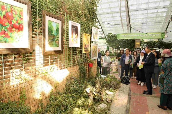 청라자원순환센터 온실에서 인천환경공단 관계자와 미술 작가들이 전시된 작품을 관람하고 있다.