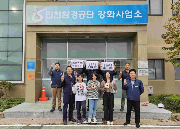 인천환경공단 강화사업소 나무에 새집을 달아주고 기념촬영을 하고 있다.