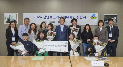 첨단보조기구 전달식에서 따뜻한동행 관계자들과 수혜 대상자들이 기념사진을 촬영하고 있다.[한미글로벌]