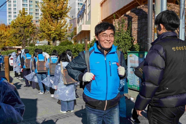 조명우 인하대학교 총장이 '대한민국 1도 올리기, 사랑의 연탄 나눔' 행사에서 학생들과 함께 연탄을 옮기고 있다.