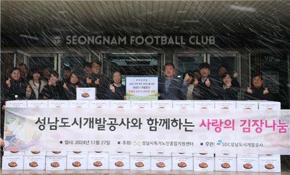 성남도시개발공사 임직원들이 성남시 독거노인종합지원센터에 김장김치를 전달 후 기념 촬영을 하고 있다.