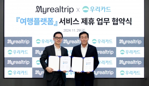 지난달 29일 우리카드 광화문 본사에서 박완식 우리카드 대표이사(오른쪽)와 이동건 마이리얼트립 대표이사가 업무 협약을 진행하고 기념사진을 촬영하고 있다. [사진=우리카드]