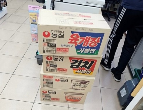 갑작스러운 비상계엄령에 한 시민이 편의점에서 라면을 대량으로 구매하고 있다. [사진 = 온라인 커뮤니티 갈무리]