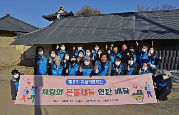 자생한방병원 임직원들과 자생봉사단원들이 '사랑의 연탄 나누기 행사'에 참석해 단체사진을 찍고 있다.