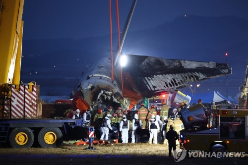 29일 오후 전남 무안군 무안국제공항에서 발생한 제주항공 여객기 충돌 폭발 사고 현장에서 파손된 기체 후미가 크레인으로 옮겨지고 있다.