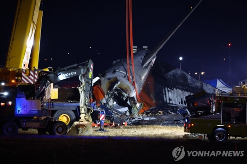 29일 오후 전남 무안군 무안국제공항에서 발생한 제주항공 여객기 충돌 폭발 사고 현장에 파손된 기체 후미가 크레인에 매달려 있다.