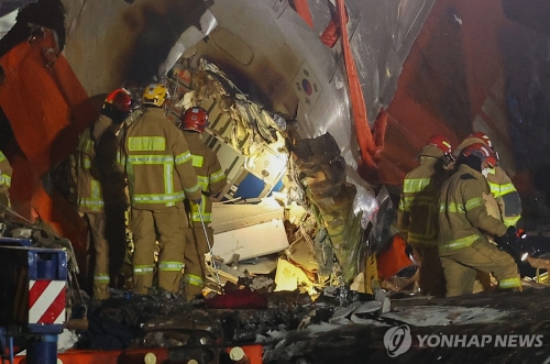 29일 오후 전남 무안군 무안국제공항에서 발생한 제주항공 여객기 충돌 폭발 사고 현장에서 소방대원들이 여객기 내부를 살펴보고 있다.