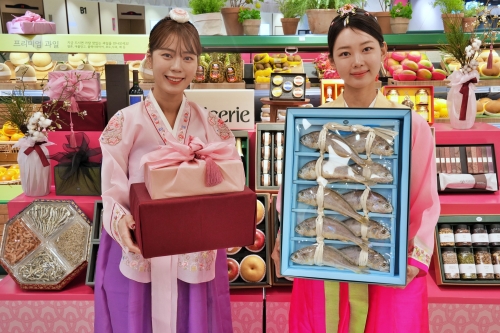 롯데백화점 잠실점 지하1층 식품관에서 2025년 설 선물세트 홍보하는 모델.