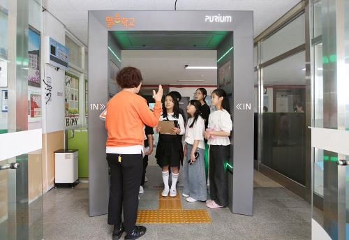 ▲ 정읍 남초등학교 학생들이 맑은학교 만들기를 통해 조성된 에어샤워를 사용설명을 듣고있다. [사진= 한화그룹 제공]