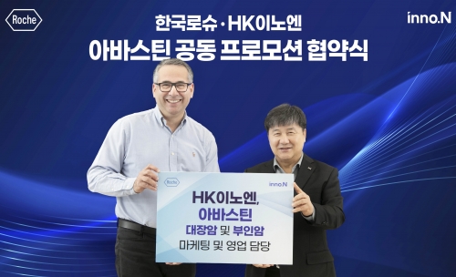 HK이노엔 곽달원 대표(오른쪽)와 한국로슈 이자트 아젬 대표이사(왼쪽)가 협약식에서 기념 촬영을 하고 있다.