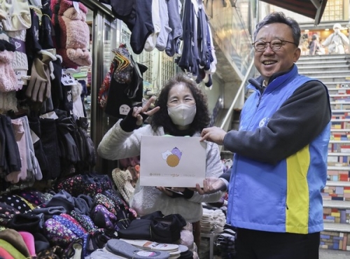 정상혁 은행장이 시장 소상공인에게 선물을 전달하고 기념촬영하는 모습. [사진=신한은행]