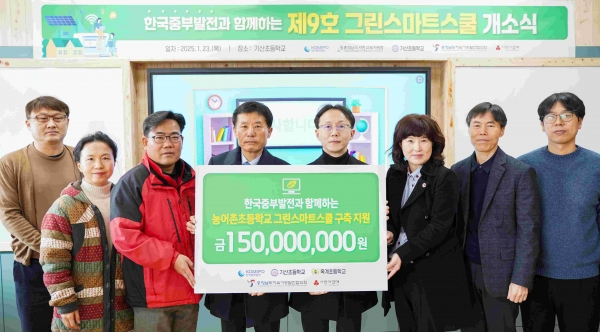 충남 서천 기산초등학교에서 제9호 그린스마트 스쿨 개소를 기념하여 한국중부발전 김민수 재무개선처장(오른쪽에서 네번째)과 허두권 기산초등학교장(왼쪽에서 네번째) 등 참석자들이 전달판을 들고 기념촬영을 하고 있다.