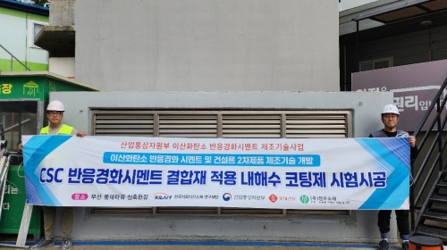 롯데건설 직원들이 부산 롯데타워 현장에서 이산화탄소 반응경화 시멘트를 활용한 코팅제를 시공하고 기념촬영을 하고 있다.[롯데건설]