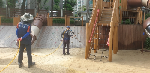 ▲ 모래놀이터 소독 작업을 하고 있는 모습 [사진= 성동구 제공]