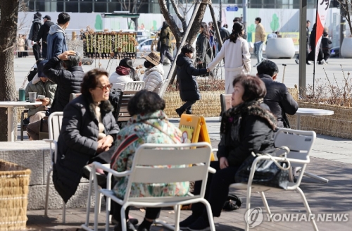포근한 날씨를 보인 27일 서울 종로구 광화문광장에 마련된 야외테이블에서 시민들이 대화를 나누고 있다.