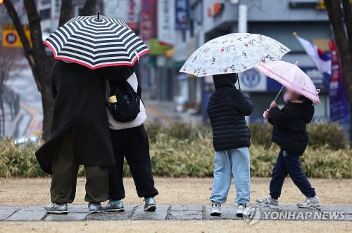 서울 한낮 기온이 12도까지 오르며 봄비가 내린 2일 서울 서대문구 서대문독립공원에서 한 가족이 나들이를 즐기고 있다.