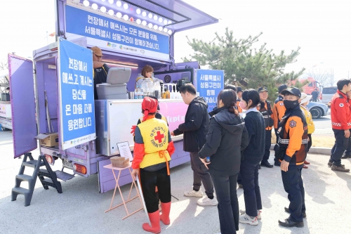 ▲ 현지 주민들과 소방대원들이 간식을 받는 모습 [사진= 성동구 제공]