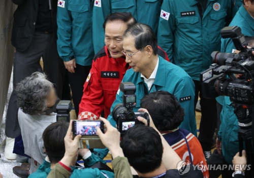 대통령 권한대행으로 직무 복귀한 한덕수 대통령 권한대행 국무총리가 24일 경북 의성군 산불 이재민 임시 대피소인 의성읍 의성체육관을 찾아 이재민들을 위로하고 있다.