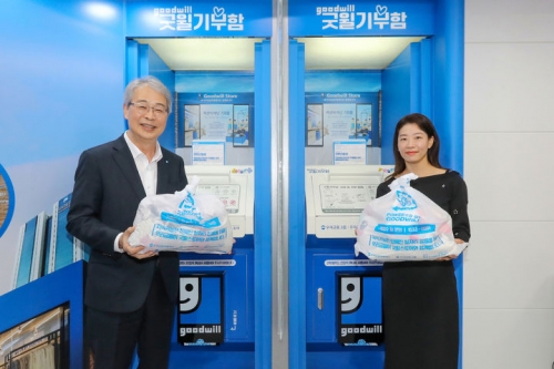 임종룡 우리금융그룹 회장(왼쪽)과 고객 대표가 굿윌기부함에 1호 기부를 하고 있다. [사진=우리금융]