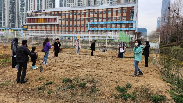 지난해 4월 행복텃밭 가꾸기 사업에 참여한 외국인들이 흙을 고르고 파종 준비를 하고 있다.(사진제공=인천경제청)