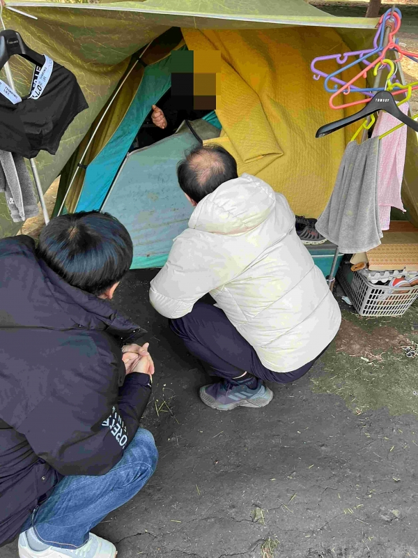 성남시노숙인종합지원센터 종사자들이 모란역 인근에 텐트를 치고 생활 중인 노숙인을 지원하려고 대화 시도 중이다.