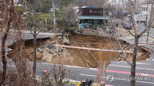지난달 25일 서울 강동구 대명초등학교 도로에서 전날 발생한 대형 땅꺼짐 현장의 모습. 전날 오후 명일동 대명초등학교 인근 사거리에서 발생한 지름 20m, 깊이 18m가량의 대형 싱크홀(땅꺼짐)에 오토바이 운전자 1명이 빠져 실종됐다.