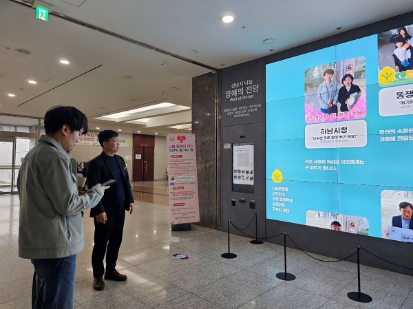 성남시청 로비에 설치된 '나눔 명예의 전당'을 벤치마킹하려고 방문한 하남시 공무원들.