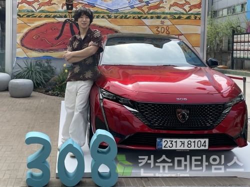 아티스트 헤르시가 푸조 308 스마트 하이브리드 차량에 기대 포즈를 취하고 있다. [사진=강나연 기자]