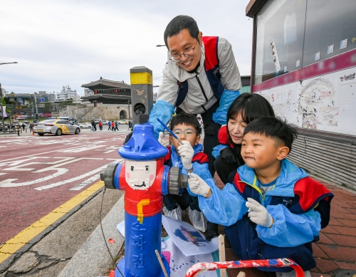 현대모비스 임직원과 가족들이 화재 예방과 시인성 향상을 위해 지상식 소화전에 도색 봉사활동을 실시하고 있는 모습