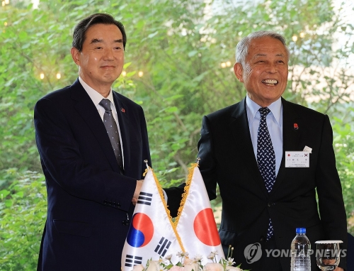 김윤 한일경제협회 회장(왼쪽)과 아소 유타카 일한경제협회 부회장이 28일 서울 시내 한 호텔에서 제57회 한일경제인회의 공동성명 채택 기자회견을 하기에 앞서 악수하고 있다.