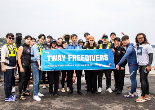 지난 5월 31일(토) 제주도 서귀포항 해안가에서 진행된 해양 정화 활동 후 티웨이항공 프리다이버스와 박상춘 제주지방해양경찰청장(가운데), 전장원 플로빙코리아 대표(오른쪽에서 첫 번째)가 기념 사진을 촬영하고 있다.