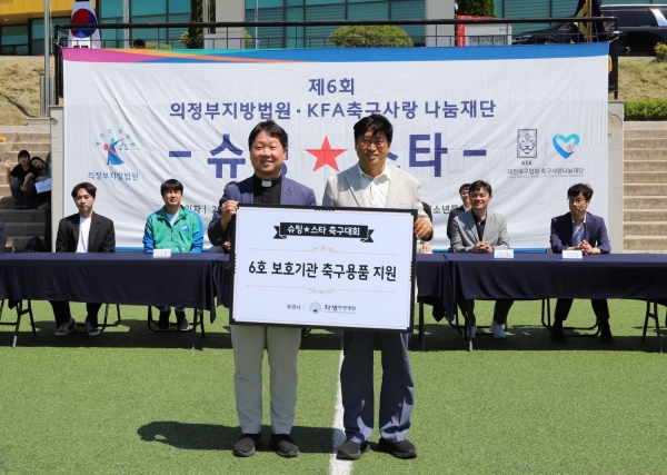 자생의료재단 신민식 사회공헌위원장(오른쪽)과 효광원 시설장 김현 신부가2025 슈팅스타 대회에서 축구용품 전달식 기념사진을 촬영하고 있다