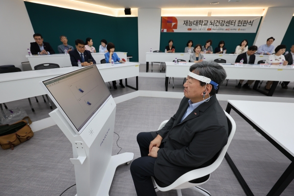 이남식 재능대학교 총장이 ㈜파낙토스가 개발한 웨어러블 EEG(뇌파 측정기기)를 착용하고 뇌파 분석 시연을 하고 있다. (사진제=재능대학교)