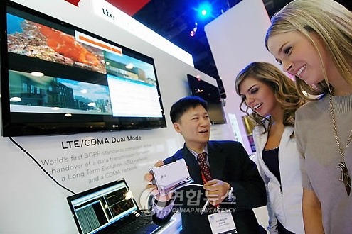 LG전자 직원이 CES 2010 LG전자 부스를 찾은 관람객들에게 LTE와 CDMA의 서로 다른 네트워크 사이에서도 자연스러운 이동이 가능한 '핸드오버(Handover)'기술을 시연하고 있다. LG전자는 LTE의 이론상 최고 다운로드 속도인 100Mbps 구현에 성공했다고 밝혔다