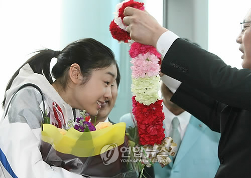밴쿠버 올림픽에서 '피겨여왕'에 오른 김연아가 2일 오후 인천공항에 도착, 유인촌 장관으로부터 환영 꽃다발을 받고 있다.