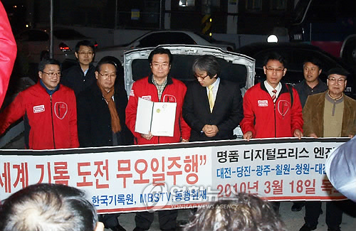 대전 ㈜모리스오일이 지난 18일 자동차 내에 있는 엔진오일을 모두 빼내고 837㎞를 달리는 데 성공, 국내 무(無)오일 주행기록을 갈아치웠다. 사진은 기록경신 직후 오세영(64.가운데) 모리스오일 대표가 한국기록원으로부터 기록인증서를 받은 뒤 포즈를 취한 모습.