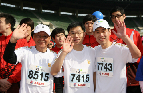 잠실 올림픽주경기장에서 개최된 '제8회 LIG 코리아오픈마라톤대회'에서 구자준(왼쪽) LIG손해보험 회장과 김필모(가운데) 노조위원장, 김우진 사장이 출발에 앞서 화이팅을 외치고 있다.