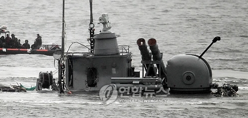 천안함 침몰사고 함미부분 인양작업중인 백령도 연화리 앞바다에서 민간해난구조업체 요원들과 해군 해난구조대 관계자들이 함미부분에 쇠사슬 2개 결색을 완료한 뒤 인양작업을 편의를 위해 함미 부분을 수심 45m 지점에서 연안쪽 수심 25m 지점으로 이동시키고 있다. 함미 일부가 모습을 드러내고 있다