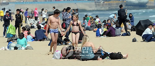 5월 첫 일요일인 2일 부산 해운대해수욕장에서 수영복 차림의 외국인들이 백사장을 걸어가고 있다. 모처럼 화창한 날씨를 보이자 해운대해수욕장에는 가족단위 나들이객들의 발길이 이어졌다.