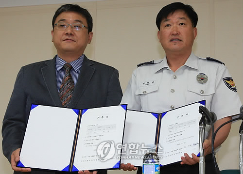 충북대학교 현상환 교수와 제주지방경찰청 백영범 작전전경계장이 25일 제주경찰특공대 강당에서 기증서에 사인한 뒤 기념촬영하고 있다. 황우석 박사가 이끄는 수암생명공학연구원은 지난 2007년 4월 제주도 실종 초등학생 수색 과정에서 뛰어난 탐지능력을 보여준 폭발물탐지견 `퀸(Quinn)'의 복제견 다섯 마리를 제주경찰청에 기증했다.