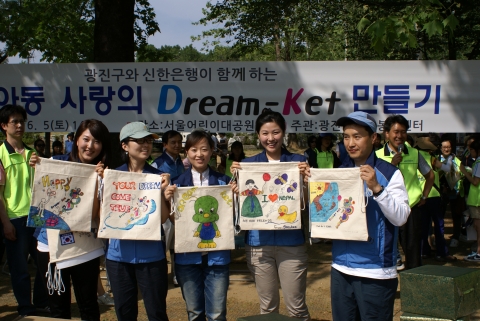 신한은행봉사단 직원들이 직접 제작한 사랑의 드림켓을 들고 기념촬영하고 있는 모습