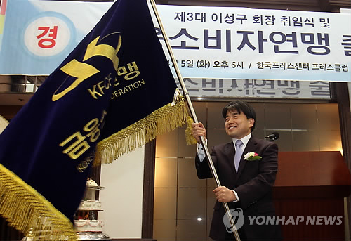 이성구 금융소비자연맹 신임 회장이 5일 오후 서울 중구 프레스센터에서 열린 연맹 출범식에서 연맹기를 흔들고 있다.